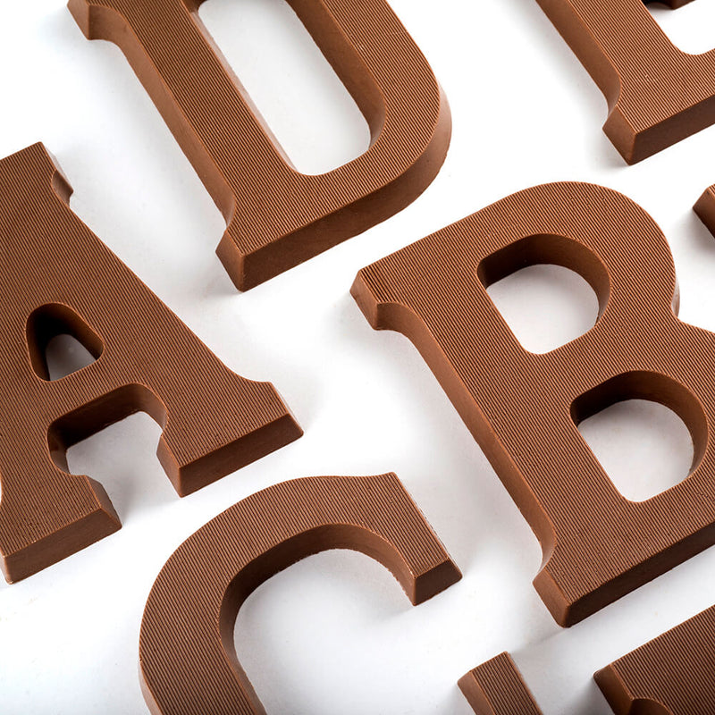 Overhead view of portions of milk chocolate letters A, B, C, D 