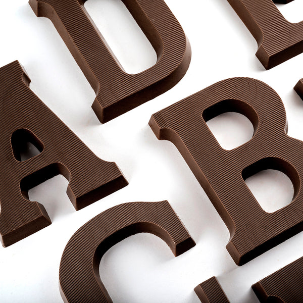 Overhead view of portions of dark chocolate letters A, B, C, D 