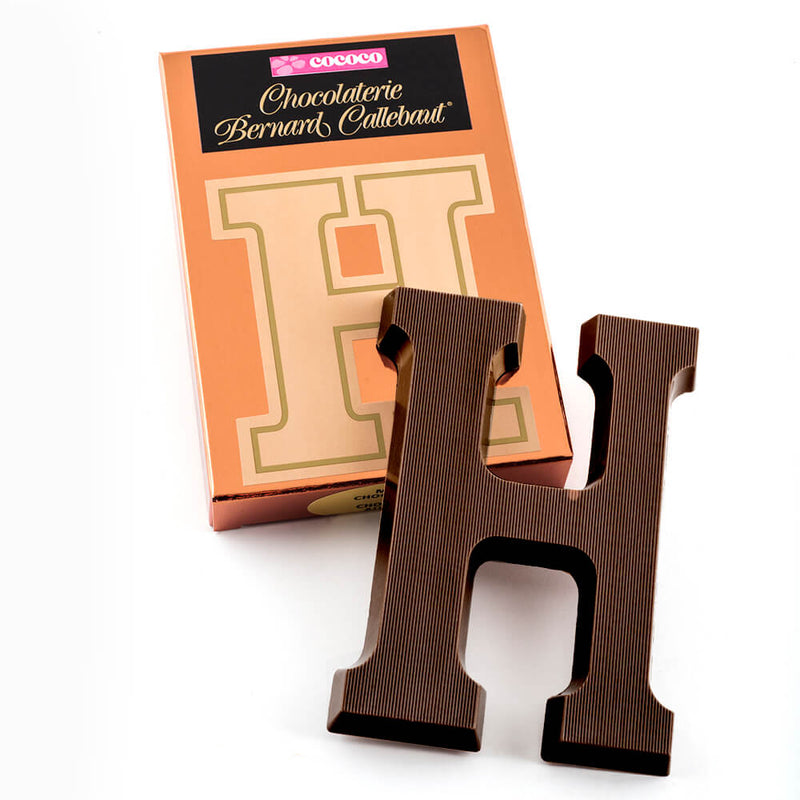 Dark chocolate letter H on top of it's Chocolaterie Bernard Callebaut®  box