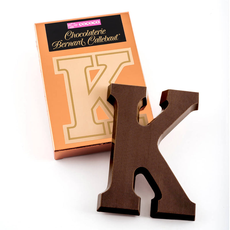 Dark chocolate letter K on top of it's Chocolaterie Bernard Callebaut®  box