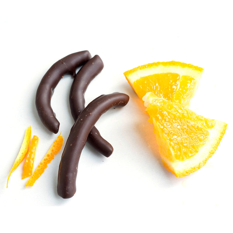 Three pieces of chocolate covered orange peel, orange rind and two slices of orange.