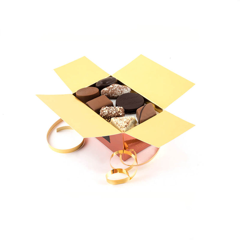 an open Chocolaterie Bernard Callebaut® copper chocolate box with gold ribbon