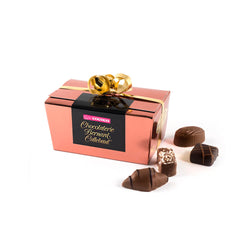Chocolaterie Bernard Callebaut® copper chocolate box with gold ribbon and four chocolates next to box