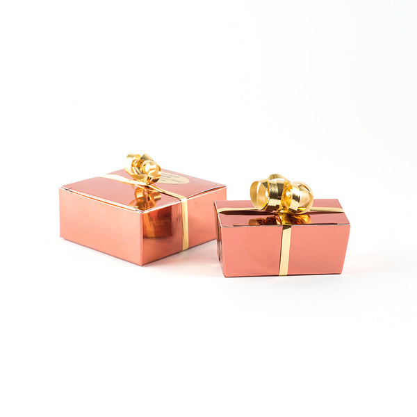 Two copper boxes dressed with shiny curly gold ribbon