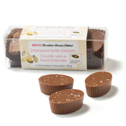 A box of four Salted Peanut Butter Chocolates, with three more chocolates in the foreground on a white surface