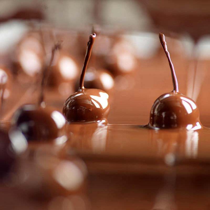 Chocolate coated cherries in a pool of melted chocolate